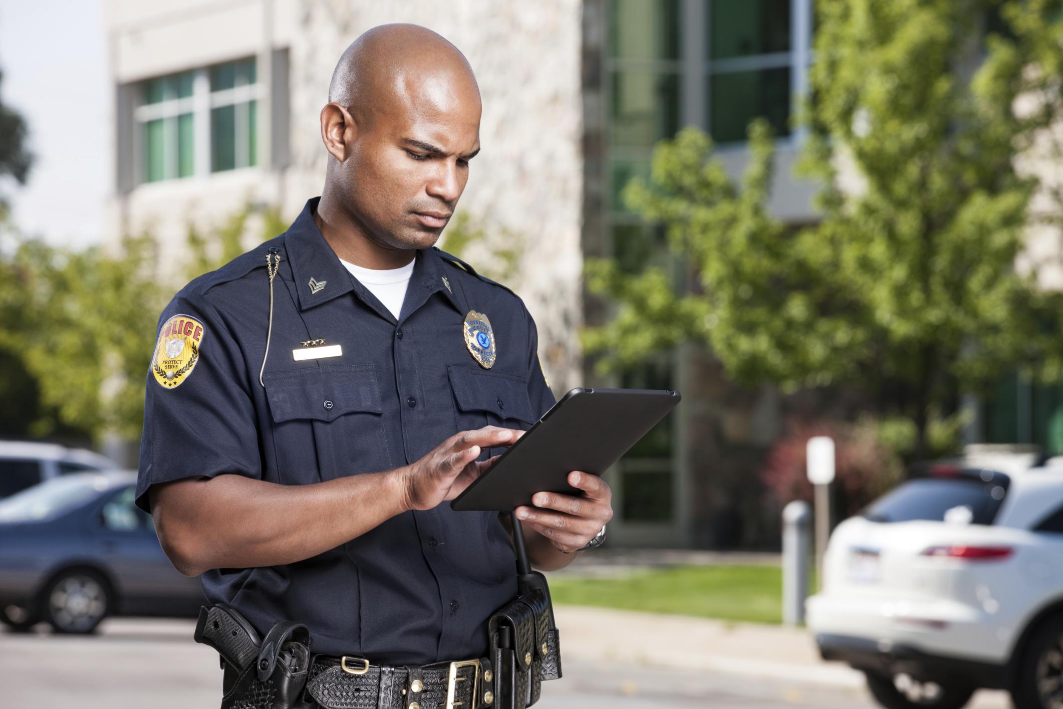 Police officer using a tablet that is managed and secured with the SOTI ONE Platform